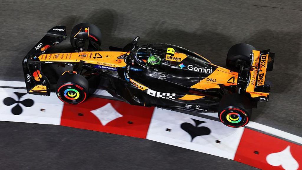 McLaren's Lando Norris steers around a kerb during Las Vegas Grand Prix practice that is decorated with playing card symbols