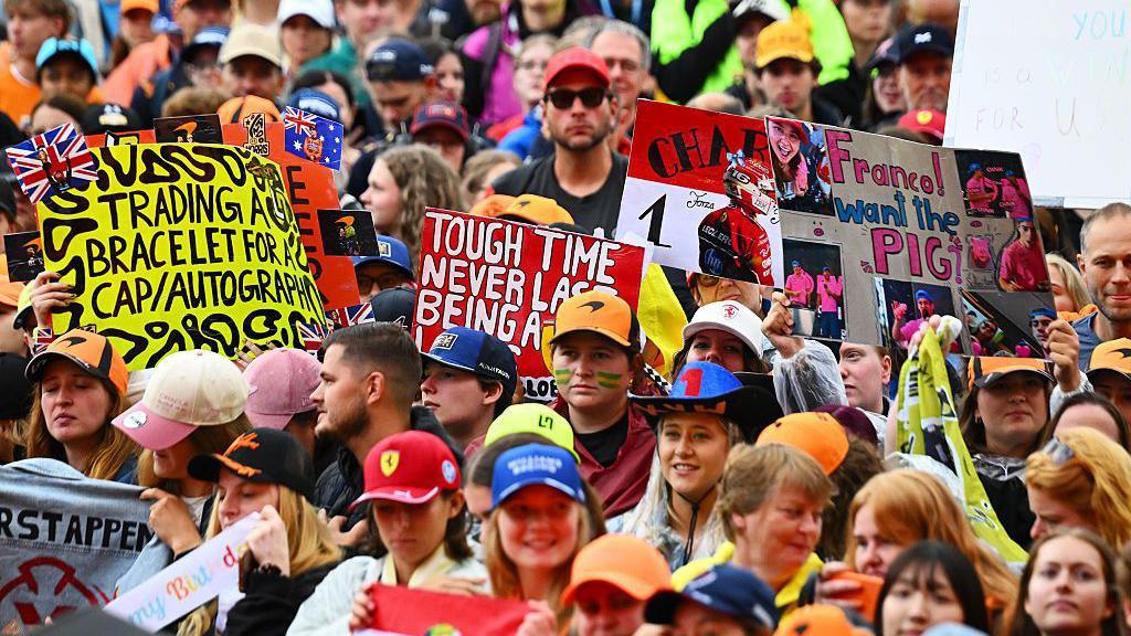 Fans hold up signs in the fan zone in Zandvoort 