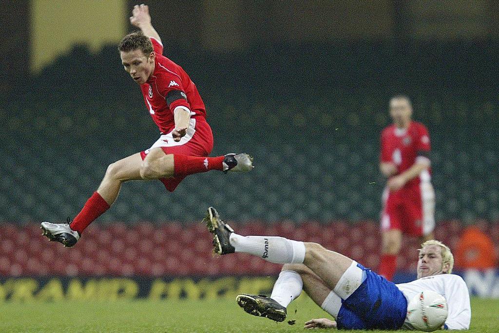 Craig Bellamy of Wales leaps over Sergej Barbarez of Bosnia-Herzegovina at the Millennium Stadium, Cardiff