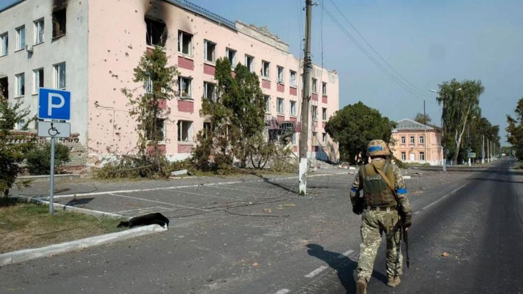 A Ukrainian serviceman walks near damaged buildings in the city center of Sudzha, in Ukraine-controlled territory of Russia's Kursk region, 21 August 2024