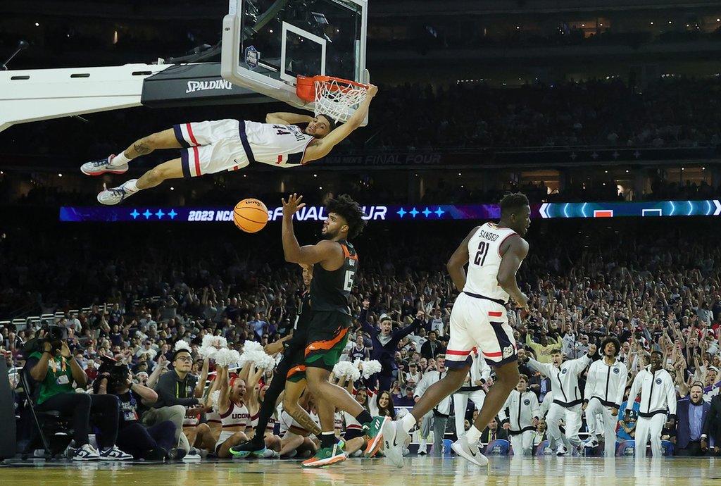 Andre Jackson Jr hangs on to the rim after scoring for the Connecticut Huskies against the Miami Hurricanes in the NCAA Final Four semi-final in Houston