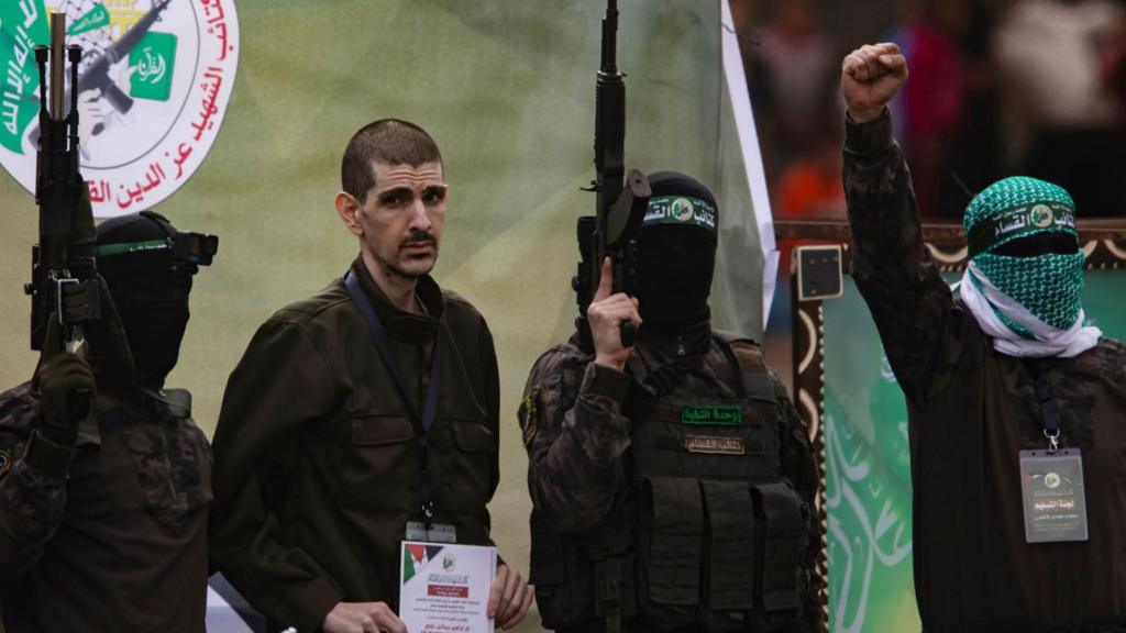 Palestinian fighters from Hamas's Izz ad-Din al-Qassam Brigades escort Israeli hostage Or Levi