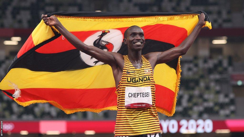 Joshua Cheptegei celebrates with a Ugandan flag after winning gold in the 5,000m at the Tokyo Olympic Games in 2021