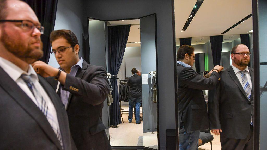 Style guide Kiavash Asghari, center, measures customer Bobby Bartlett, of Germantown, Md., on a new suit purchase at Indochino in Tyson's Galleria on January 12, 2018 in McLean, Va. (Photo by Ricky Carioti/The Washington Post via Getty Images)