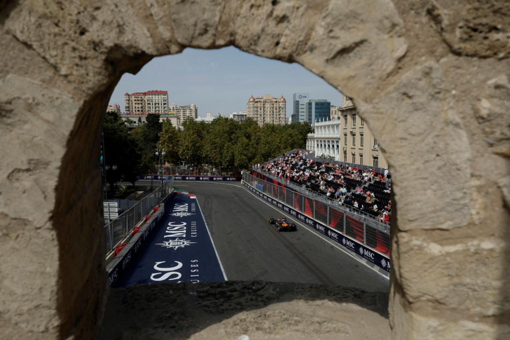 A view of McLaren's Oscar Piastri during Azerbaijan Grand Prix first practice through a hole in a castle wall