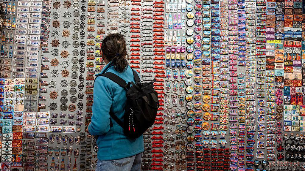 A shopper looks at magnets at a gift store in the Chinatown neighborhood of San Francisco, California, US, on Wednesday, June 25, 2025.