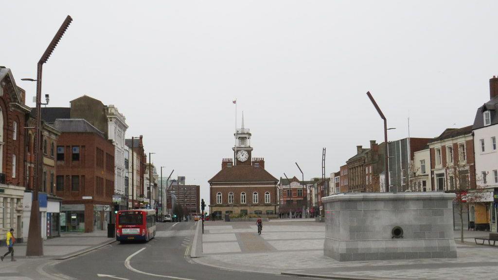 Stockton town centre. An old town hall is in the background with a clock tower. The area looks empty on the day the photograph was taken.