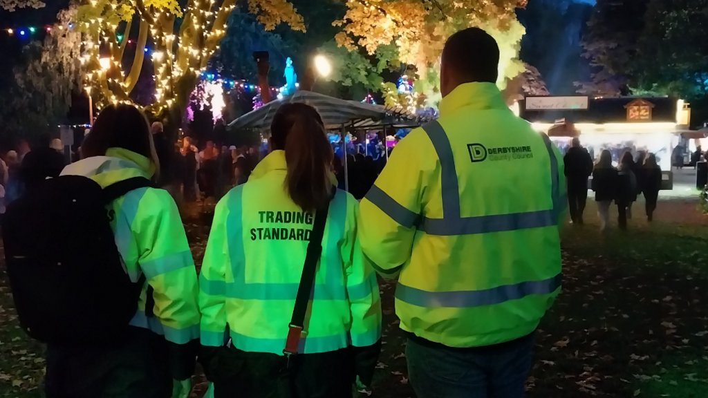 Three people in high-vis trading standard coats at Matlock Bath Illuminations