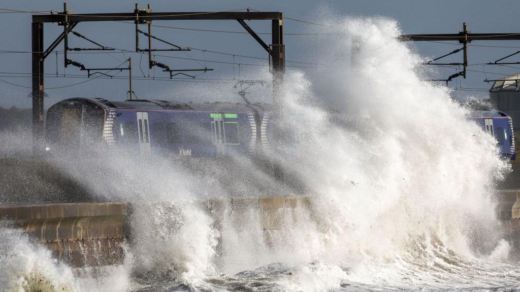 train gets hit by sea waves during storm.