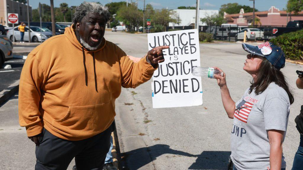 A Trump supporter clashes with a protestor outside a hearing in Mr Trump's classified documents case