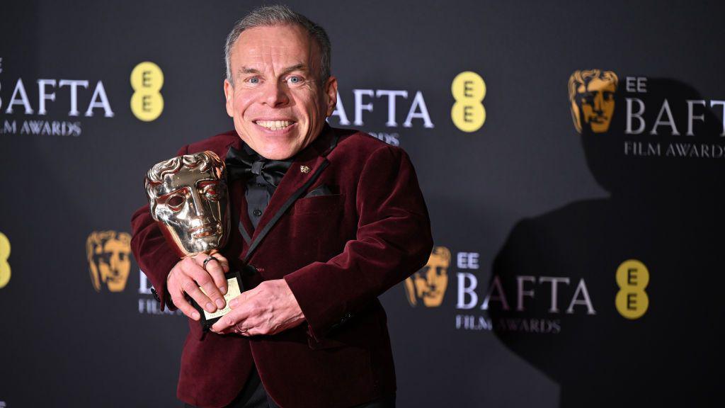 Warwick Davis with award