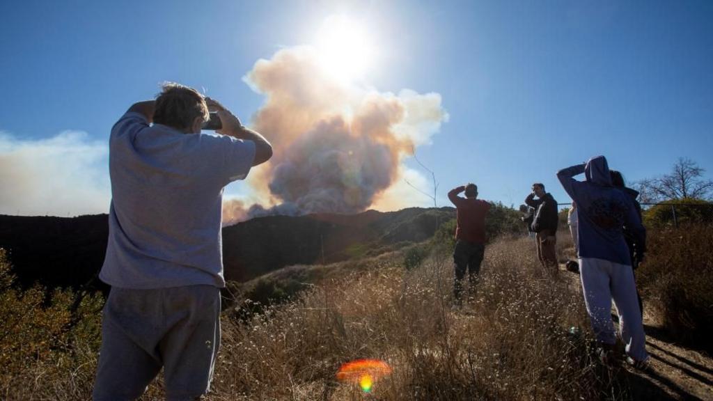 People watch smoke rising from the Palisades Fire