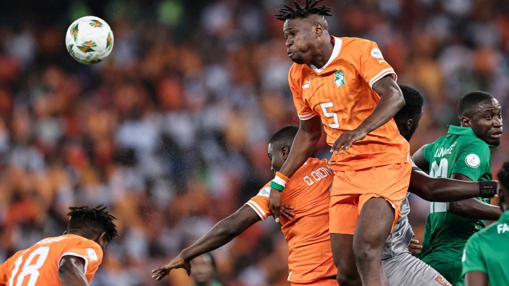 Ivory Coast defender Wilfried Singo heads the ball against Guinea-Bissau