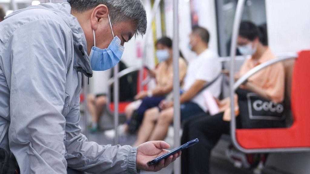 Man with phone on Beijing subway