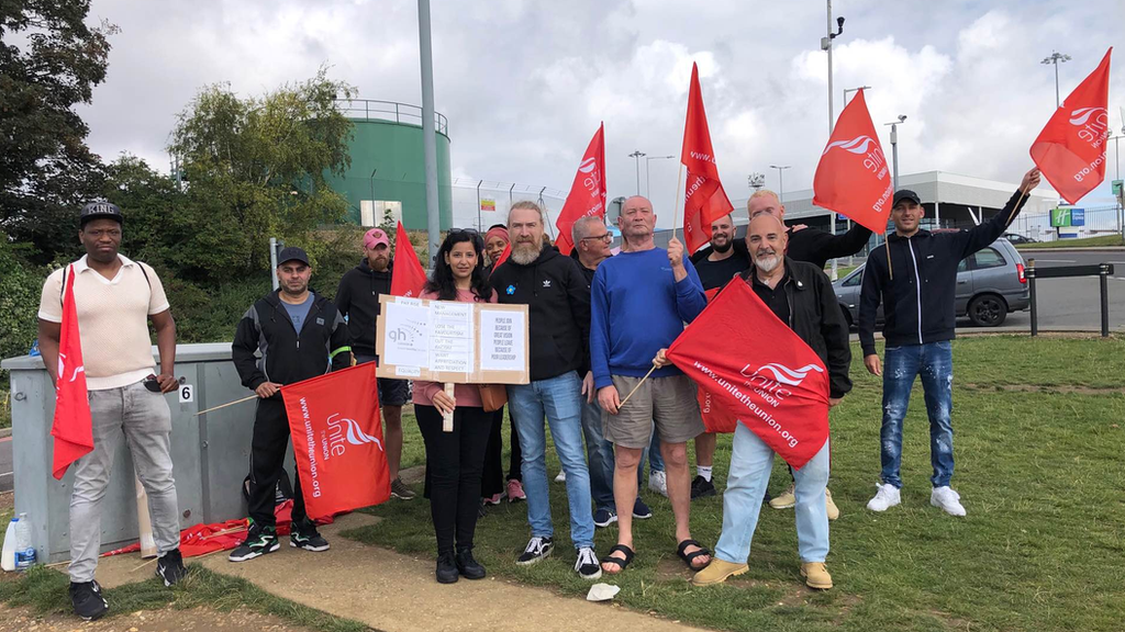 Workers holding flags and posters striking over pay and working conditions at Luton airport