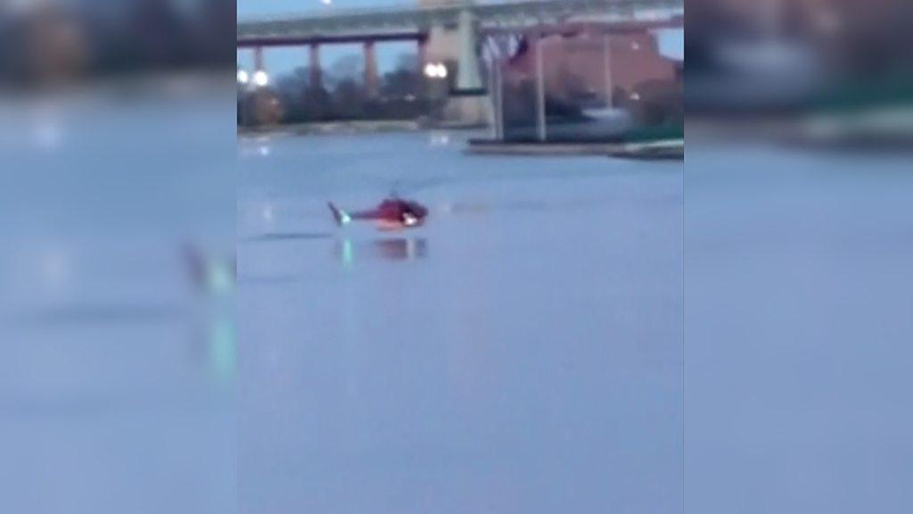 A red helicopter about to crash into a river