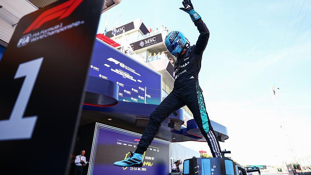 George Russell jumps out of his Mercedes in celebration after taking pole position for the Barcelona-Catalunya Grand Prix