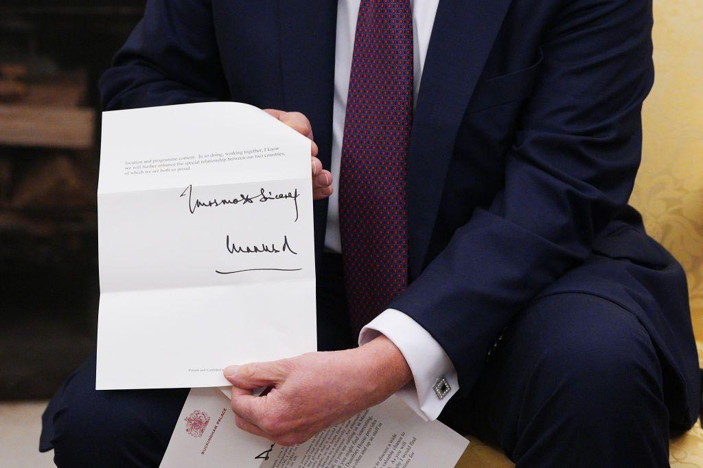 
Close up image of King Charles' signature, on letter held by Donald Trump