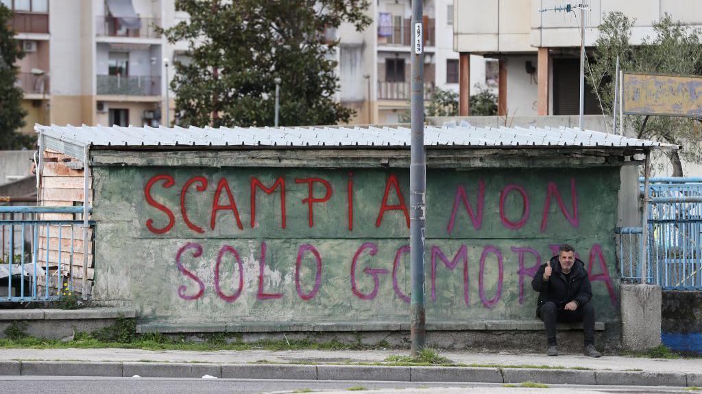 A graffiti near the housing estate that reads "Scampia is not just Gomorrah"