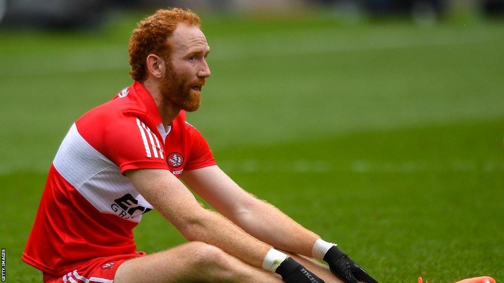 A dejected Conor Glass sits on the pitch after the game