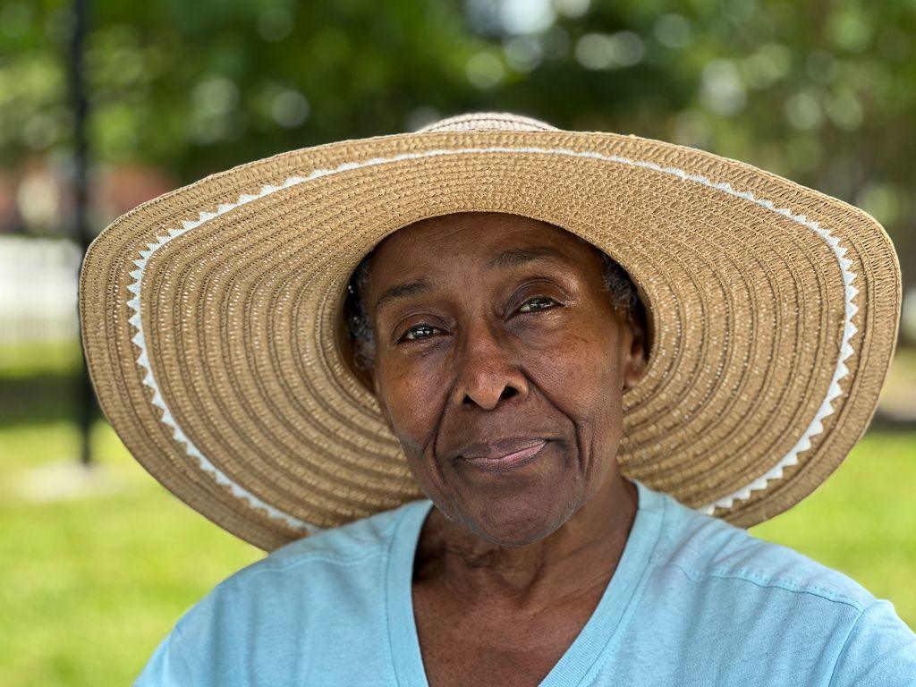 Mary Porter wears a straw hat and a blue t-shirt