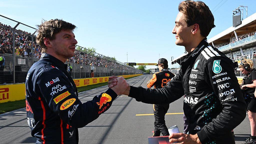 Max Verstappen and George Russell shake hands on track at the Canadian Grand Prix