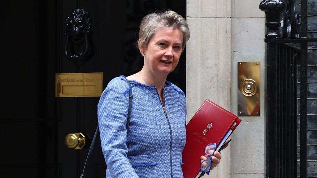 Yvette Cooper leaving Downing Street, wearing a blue suit and carrying a red folder