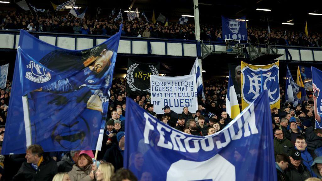 Everton fans hold flags and banners at Goodison Park