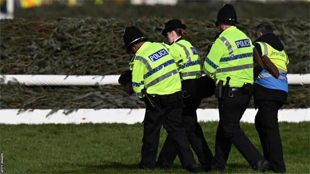 An animal rights protester is taken away by police officers