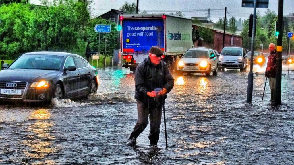 Man walks through flood in Selly Park