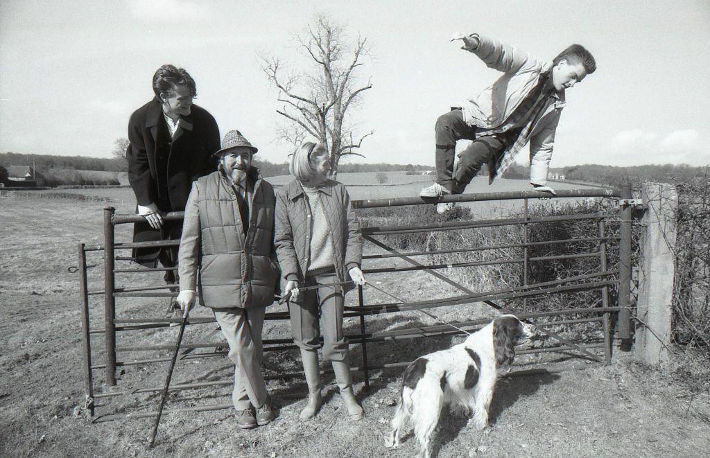 English actor Maggie Smith with her family in their country home in Sussex.  Husband Beverley Cross and her two sons. Chris watches his brother Toby as he vaults the gate in 1986 (photo by Ian Cook/Getty Images)