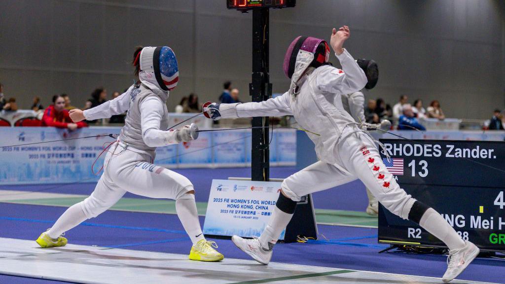 Zander Rhodes of United States (L) and Leung Mei Hang of Canada (R) competes during the table of 64 round in the FIE Women's Foil World Cup at the AsiaWorld Expo in Hong Kong, China