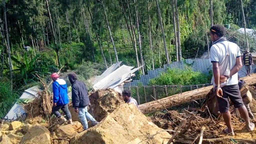 People gather at the site of a landslide in Maip Mulitaka in Papua New Guinea's Enga Province on May 24, 2024.