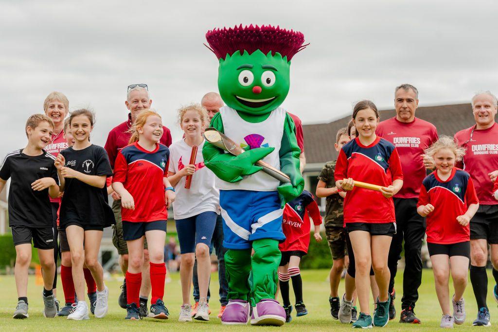 Children meet Clyde the Scotland team mascot with the Queen's baton during activities including cricket, running and hockey at the Dumfries sports club during the Birmingham 2022 Queen's Baton Relay
