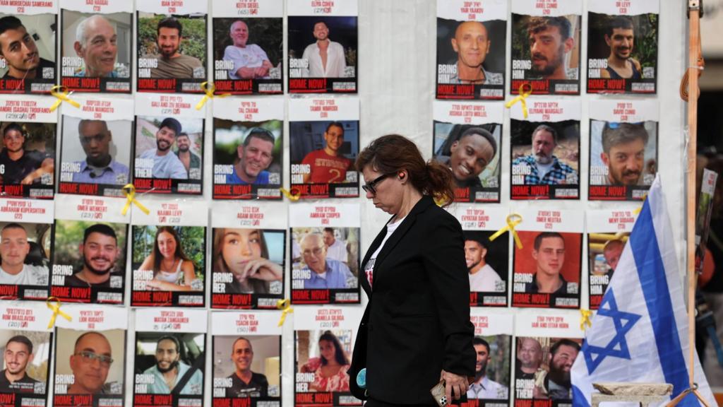 A woman walks past a display of posters calling for the release of Israeli hostage