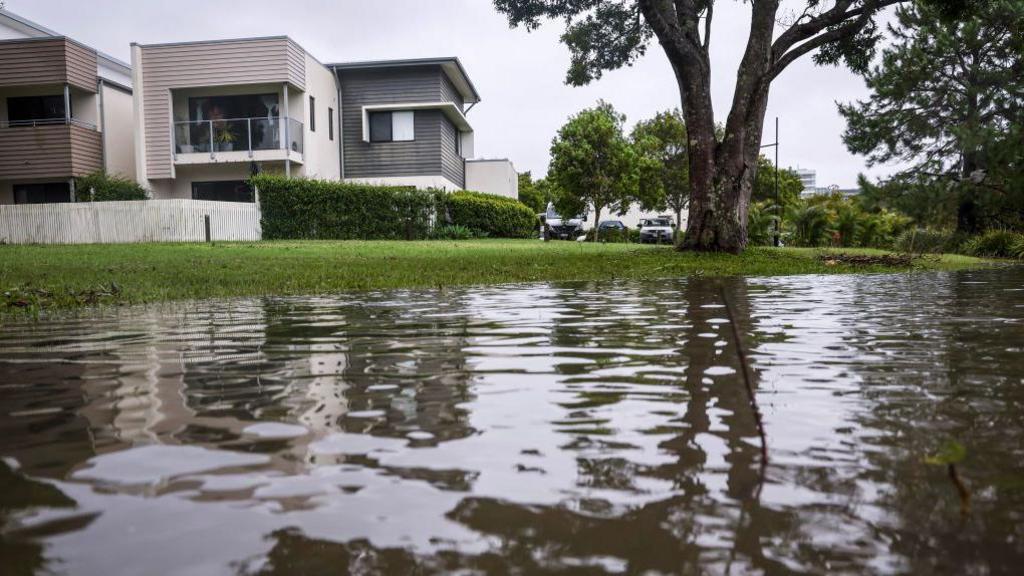 Floodwater is pictured next to homes in the suburb of Tugun following heavy rain brought by Cyclone Alfred on the Gold Coast on March 8, 2025.