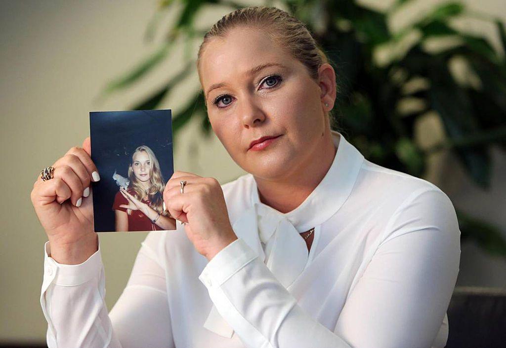 Virginia Giuffre holding a photo of herself as a teen.