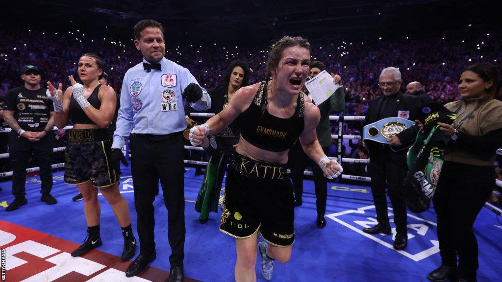 Katie Taylor celebrates as the scorecards are read out with Chantelle Cameron applauding in the background