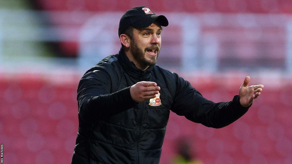 Gavin Gunning gestures from the sidelines during a Swindon game