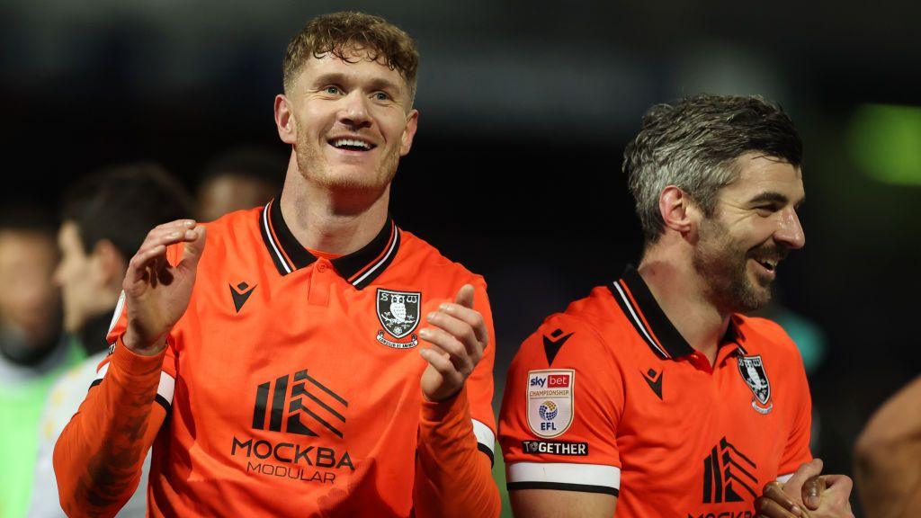 Sheffield Wednesday's Michael Smith, who scored the opening goal,  claps the fans at the end of his team's win at Queen's Park Rangers, alongside Callum Paterson, who scored the second