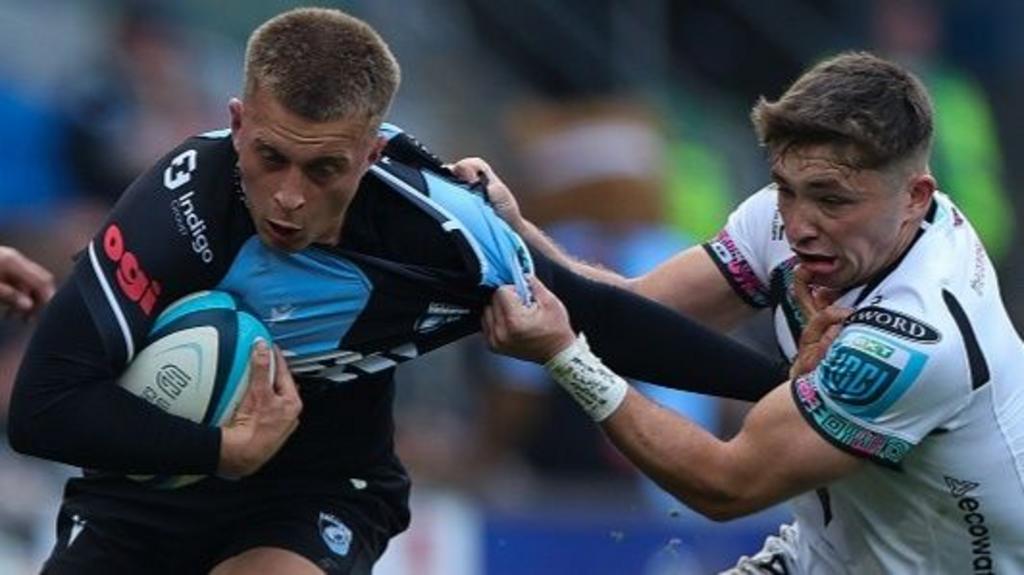 Cardiff's Cameron Winnett (L) is tackled by Dan Edwards of Ospreys