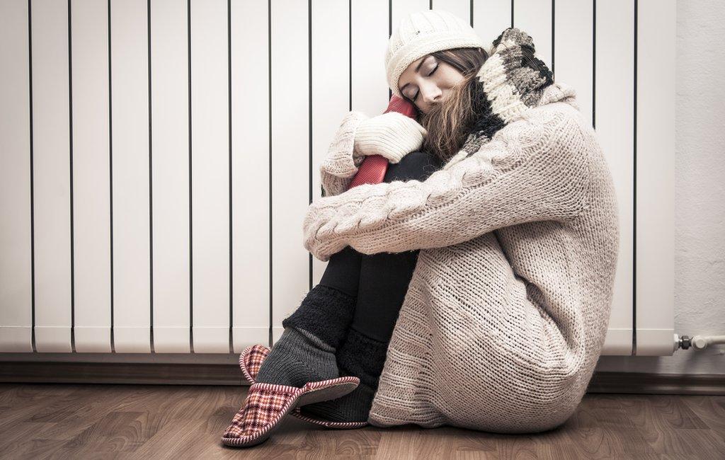 woman hugging waterbottle by radiator