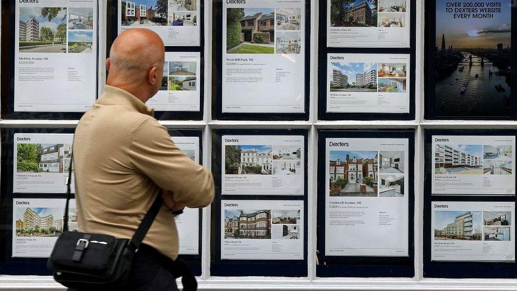 A man looks at houses for sale