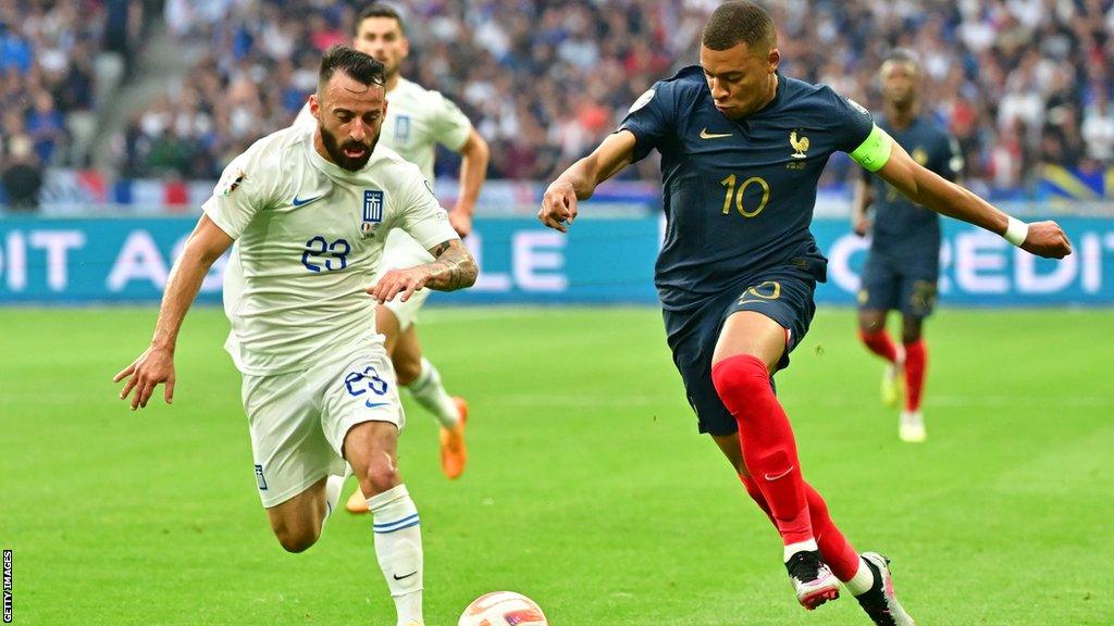 Manolis Siopis (left) takes on Kylian Mbappe