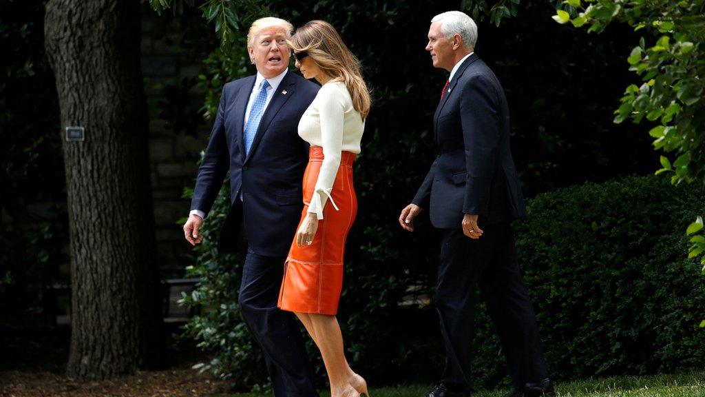 US President Donald Trump looks back toward his wife Melania and Vice-President Mike Pence as he departs the White House