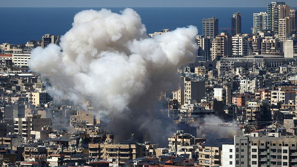 Smoke rises after an air strike in the suburbs of Lebanon's capital Beirut on 9 March. The area is densely populated with high rise buildings.
