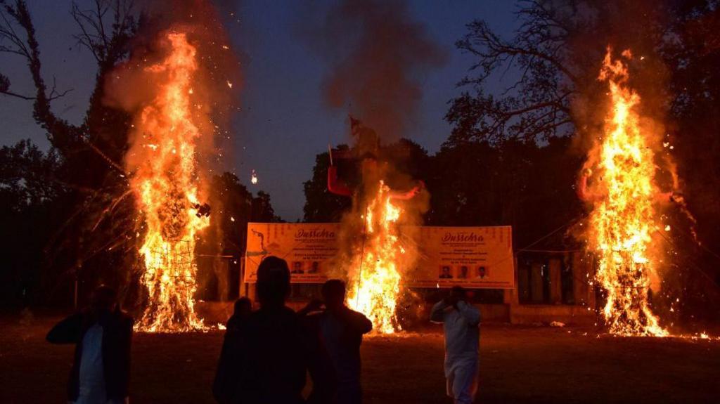 Effigies of the demon king Ravana, his son Meghnath and brother Kumbhkaran burn during the Dussehra festival in Srinagar. 