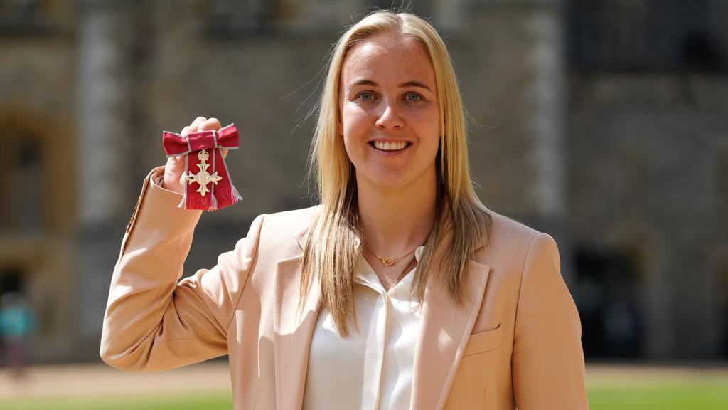 Beth holding up her MBE