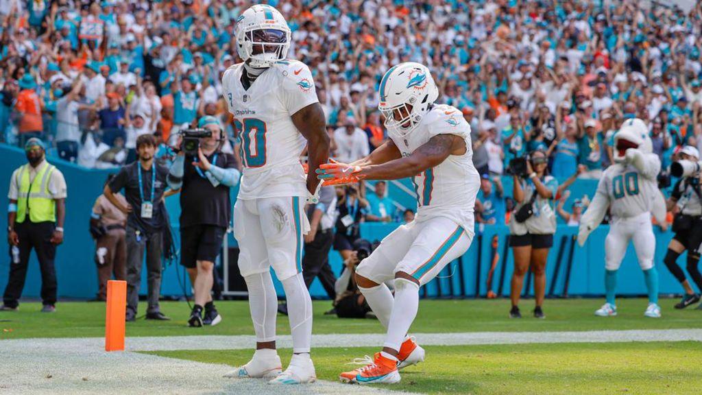 Tyreek Hill, pictured left, celebrates a touchdown by pretending to be in handcuffs hours after he was detained by Miami police on Sunday 