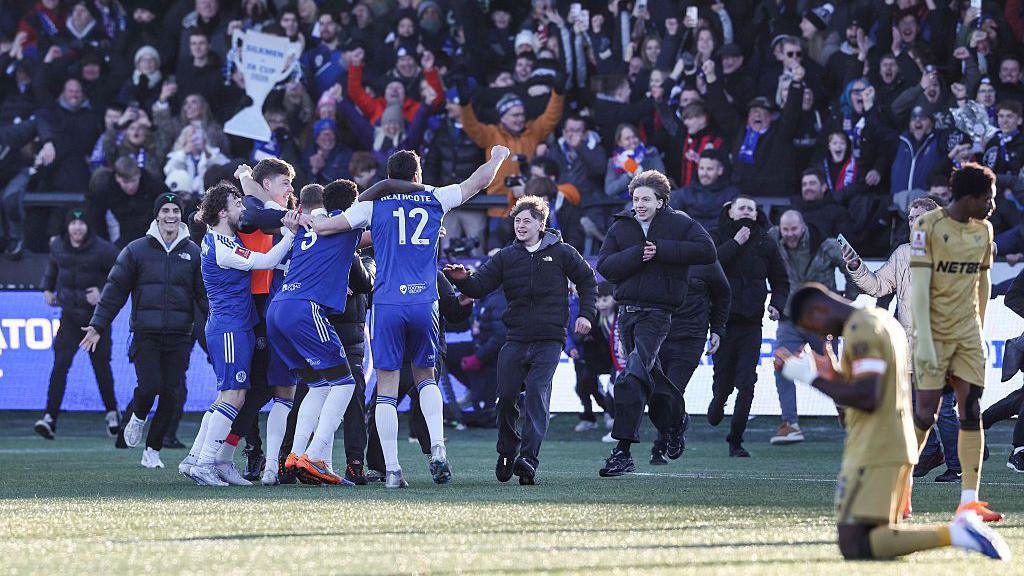 Fans race on to the pitch at full time to celebrate Macclesfield's win